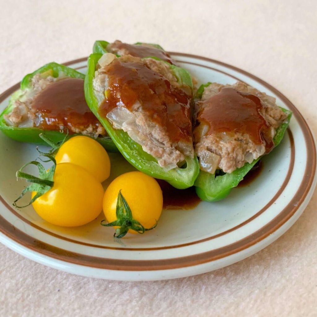 黄色いプチトマトが添えられたピーマンの肉詰め