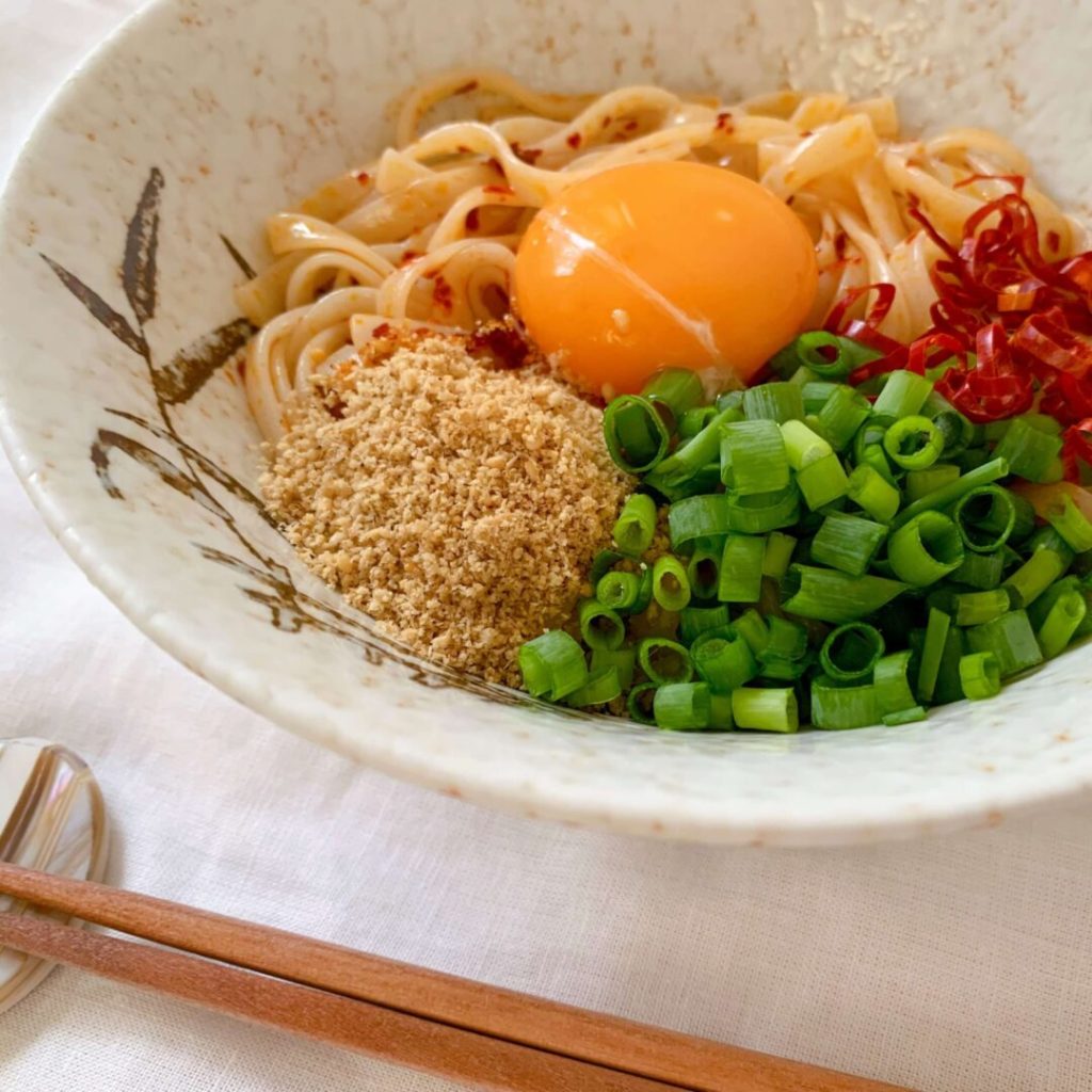 生卵やネギが乗ったうどん