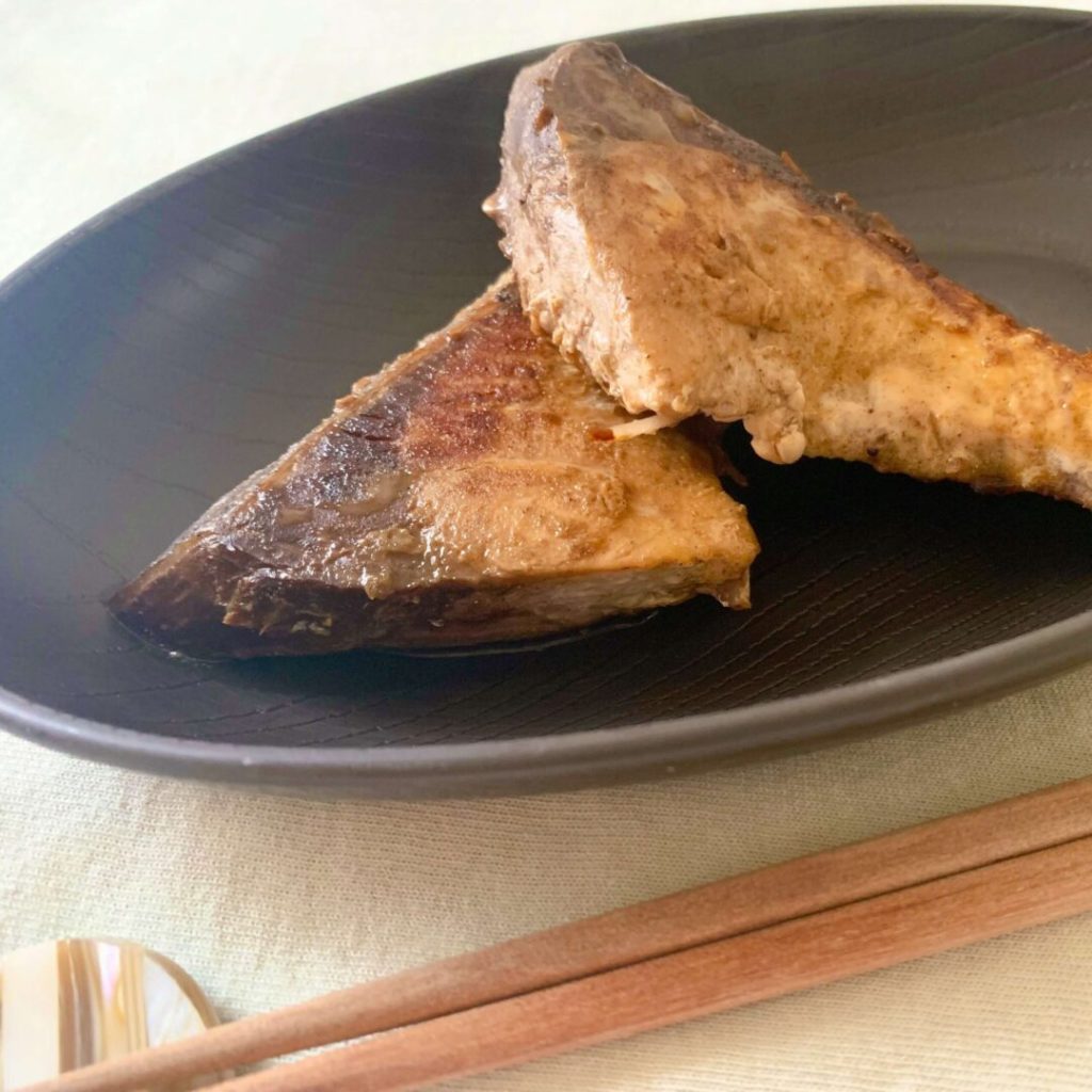 黒い皿に盛られたブリの塩焼き